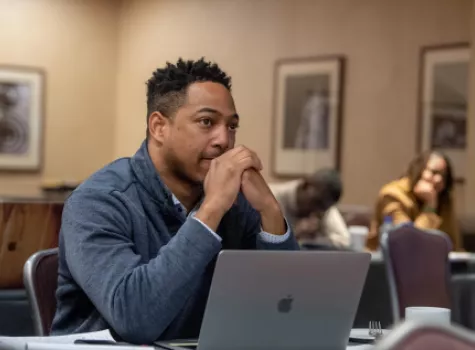 Male sitting at laptop in board meeting
